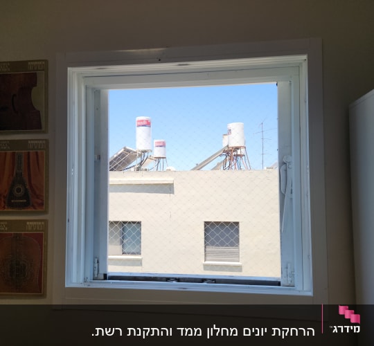 חלון פתוח עם דודי שמש על גג בניין